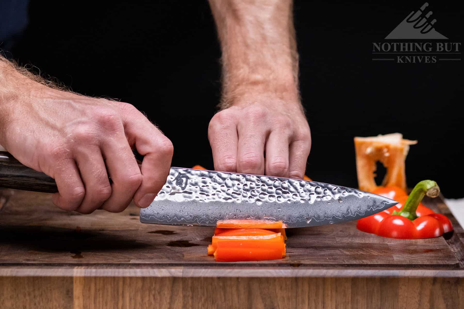 This image illustrates the proper way to hold the Shun Premier chef knife in a pinch grip. 