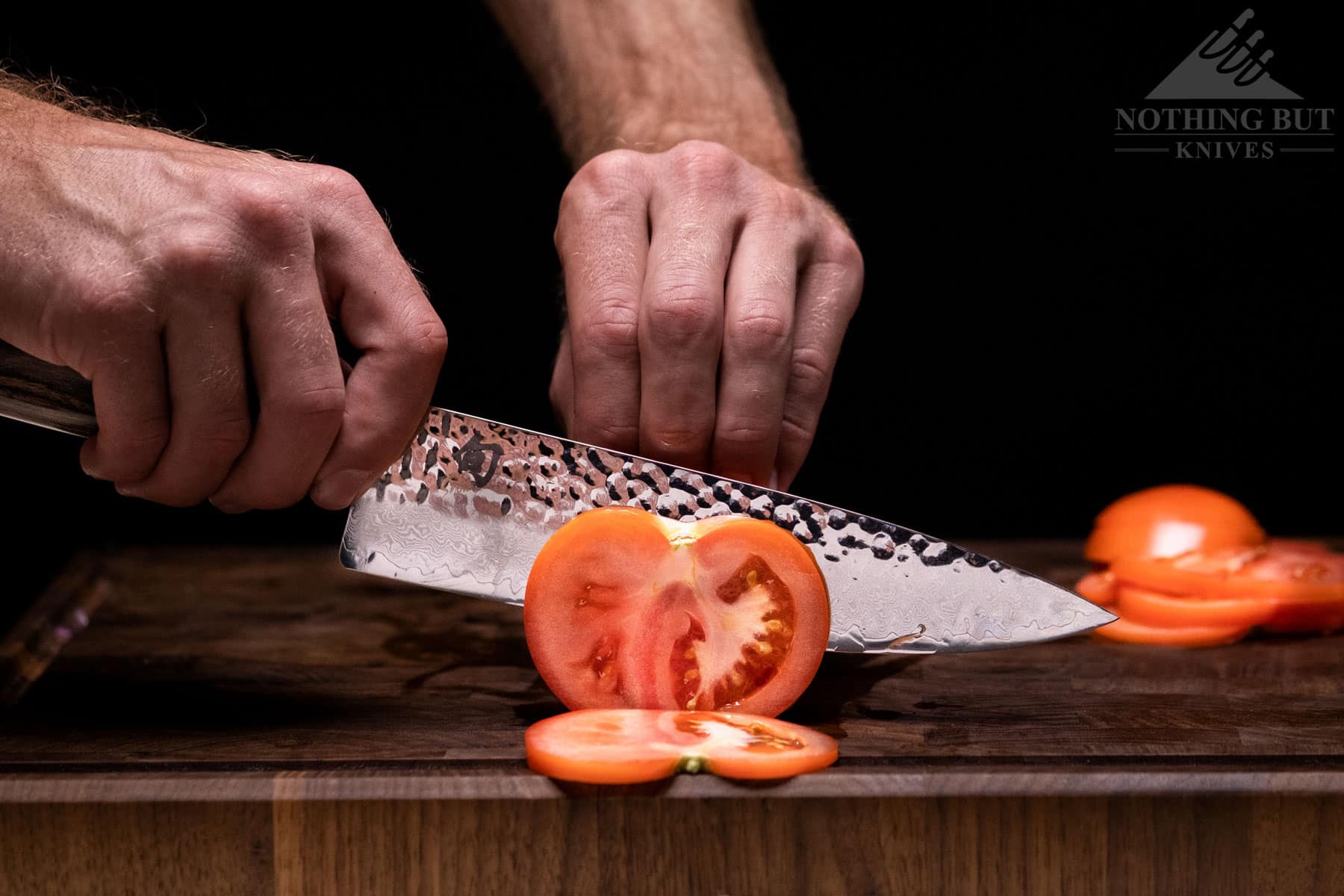 The Shun Premier chef knife easily slicing through a tomato to show the blades sharpness.