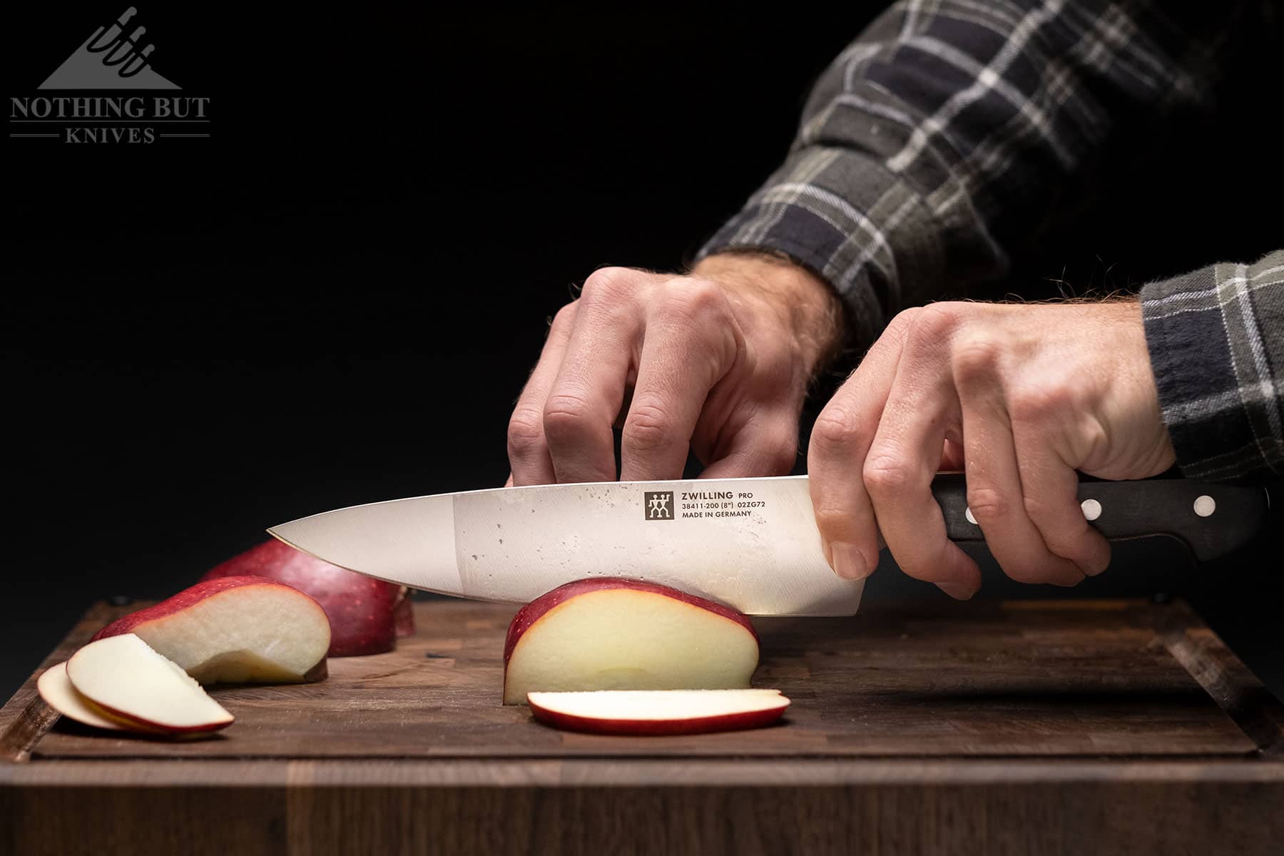 Slicing an apple with the Zwilling Pro chef knife to show its scale and cutting ability. 