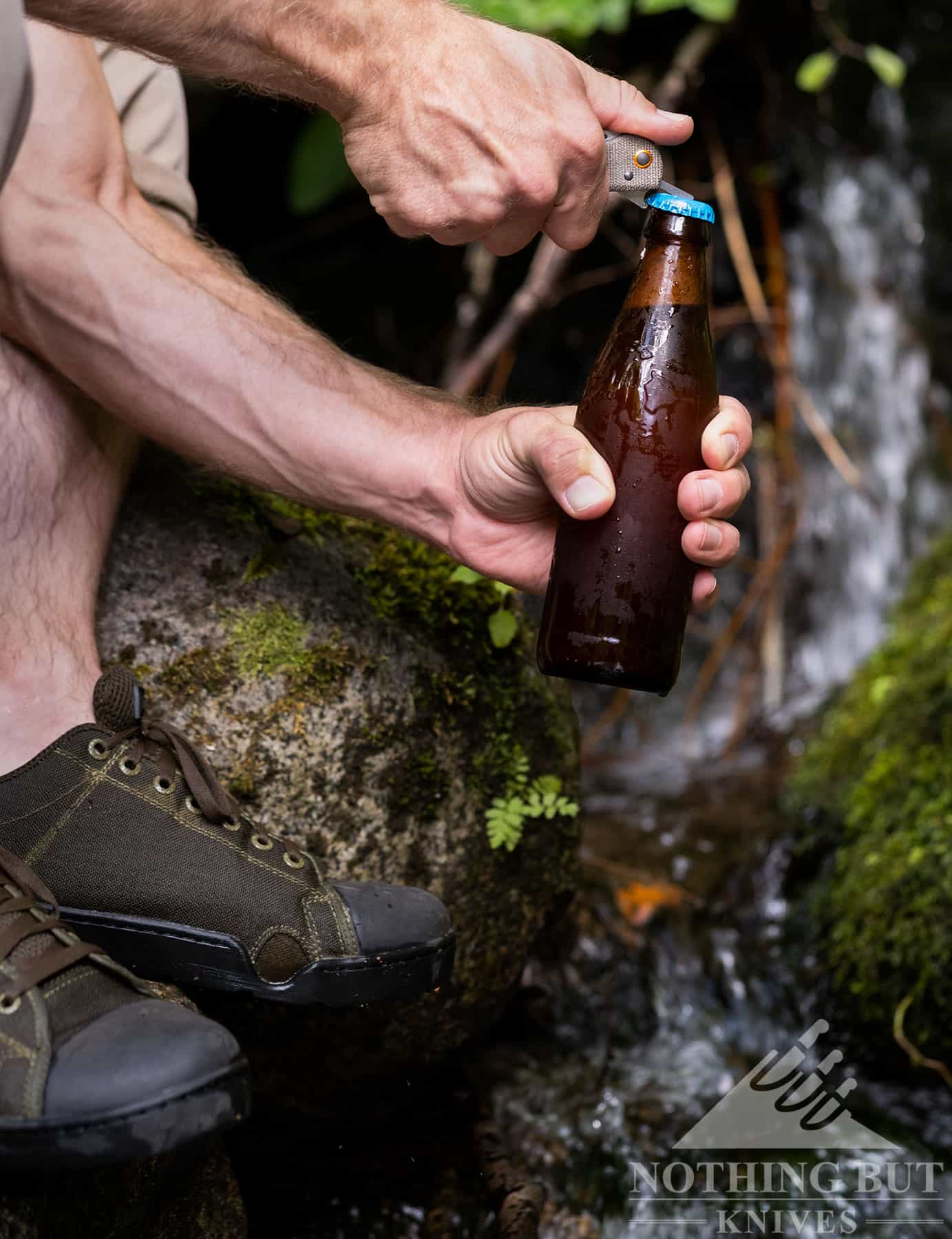 The Benchmade Weekender bottle opener blade being used to open a beer in the mountains. 