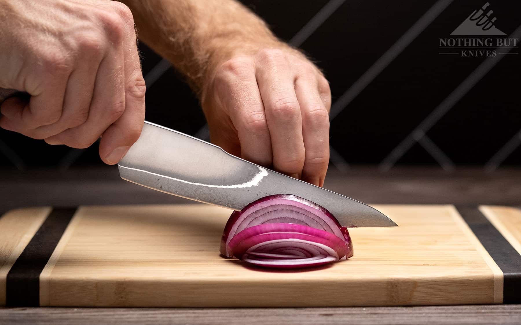 The XinCraft 8.4 inch chef knife shows its slicing prowess in this image of it being used to cut up an onion.  