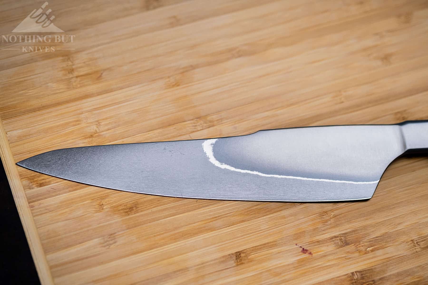 This close up of the XinCraft 8.4 inch knife blade shows its rustic design and San Mai lines. 