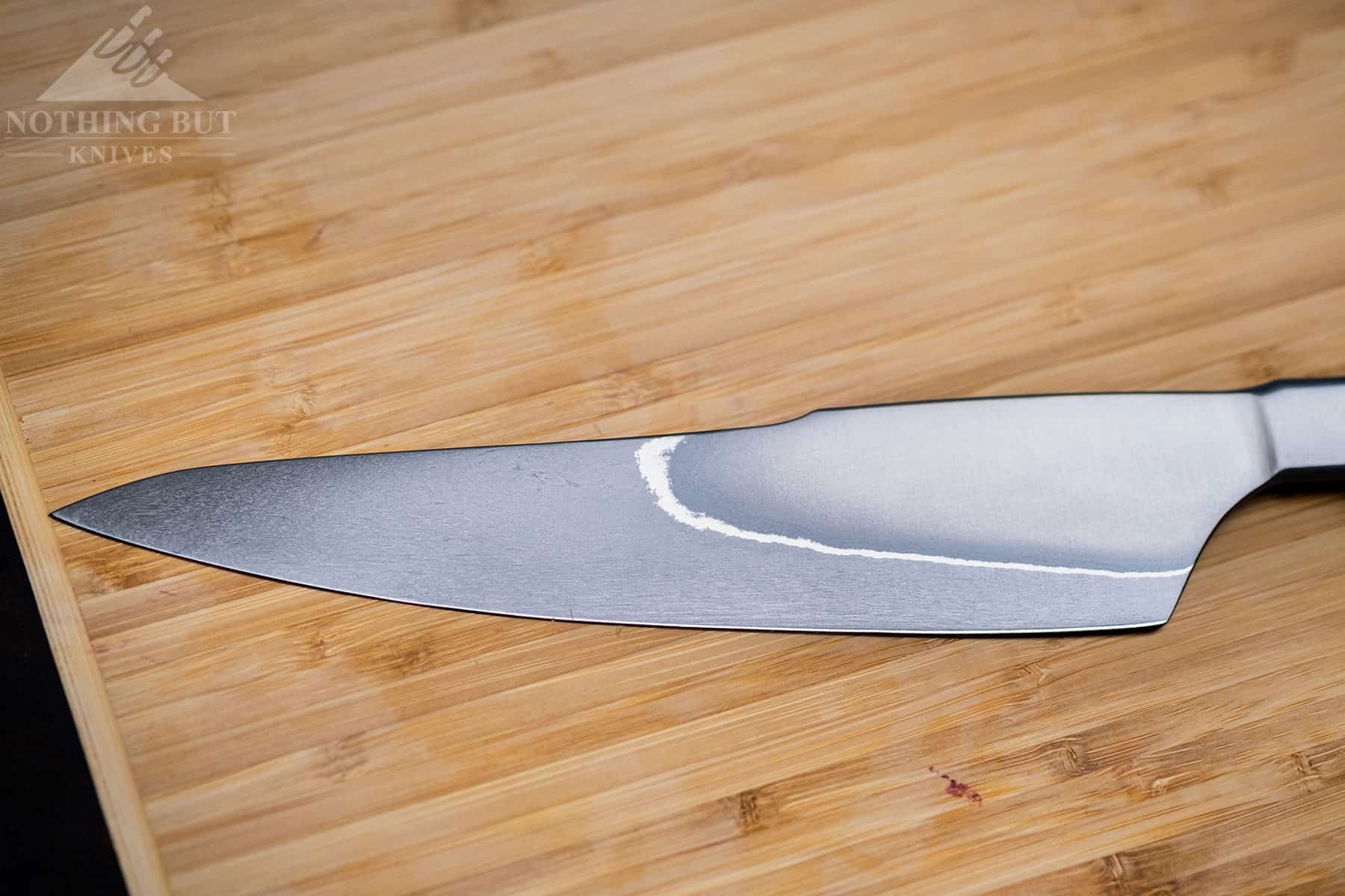 Xin Cutlery Xincraft 8.4&Quot; Chef'S Knife Review - Image 4 This close up of the XinCraft 8.4 inch knife blade shows its rustic design and San Mai lines.