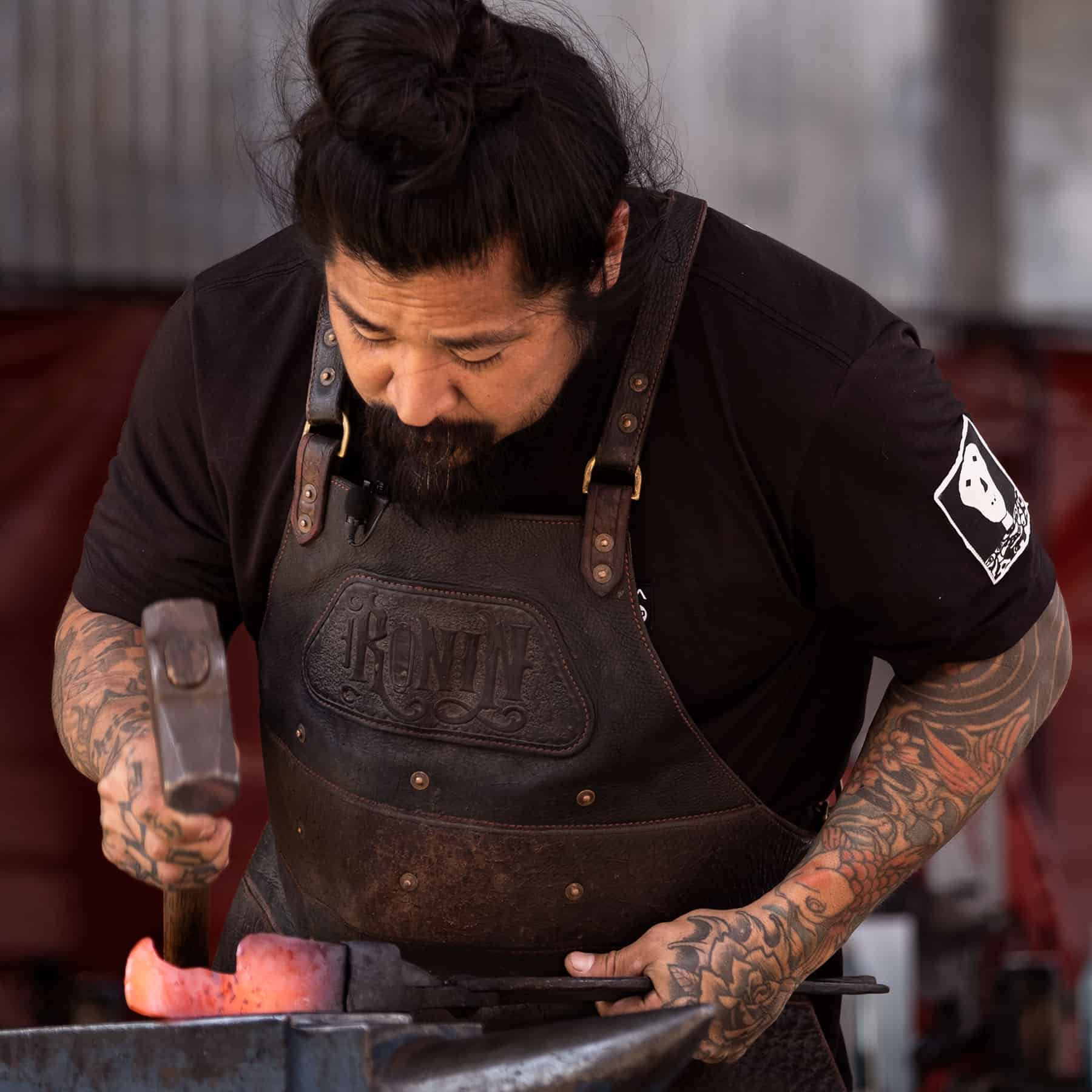 Neil Kamimura hammering a kitchen knife during the live forging session at Forged To Table 2022.