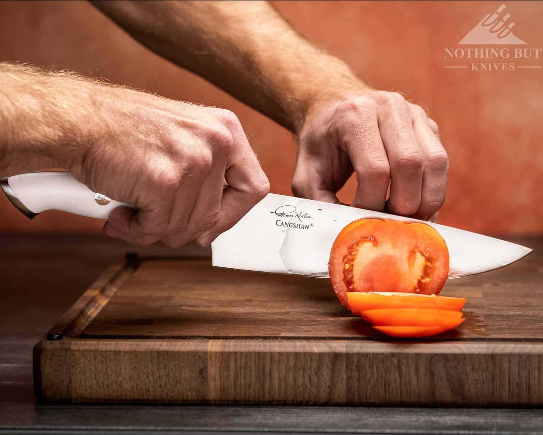 The edge of the Cangshan Thomas Keller chef knife has a good bite that cuts right into soft skins as this photo of it cutting a tomato shows.