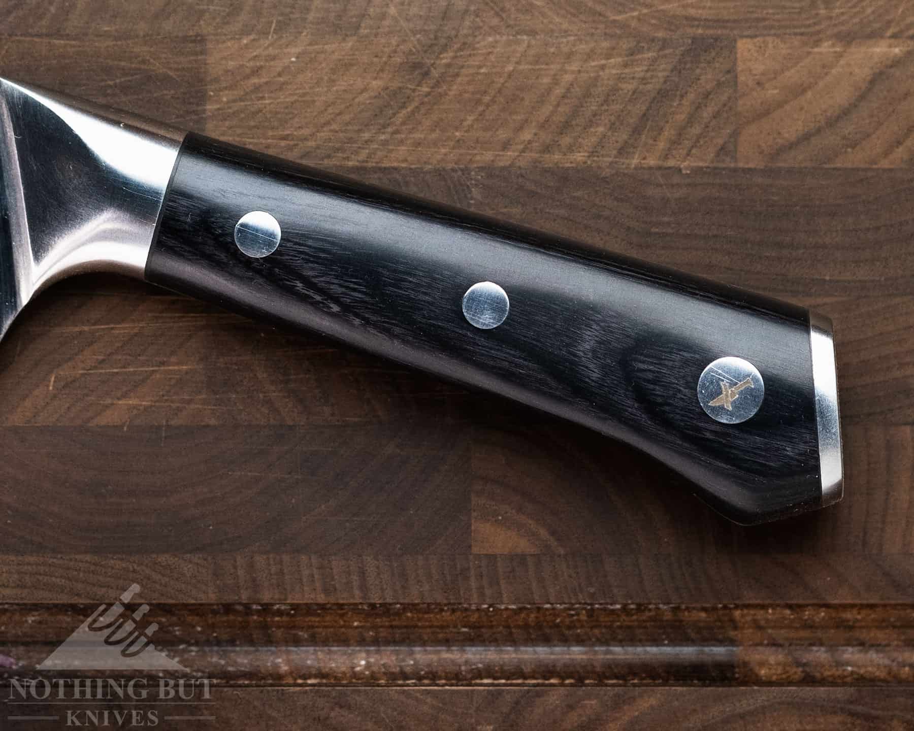 Cutluxe Artisan Chef'S Knife Review - Image 7 The handle of the Cutluxe Artisan chef knife has a way of locking into your palm, but since the corners are so smooth and heavily rounded, it’s still easy for to shift your grip when cutting food.