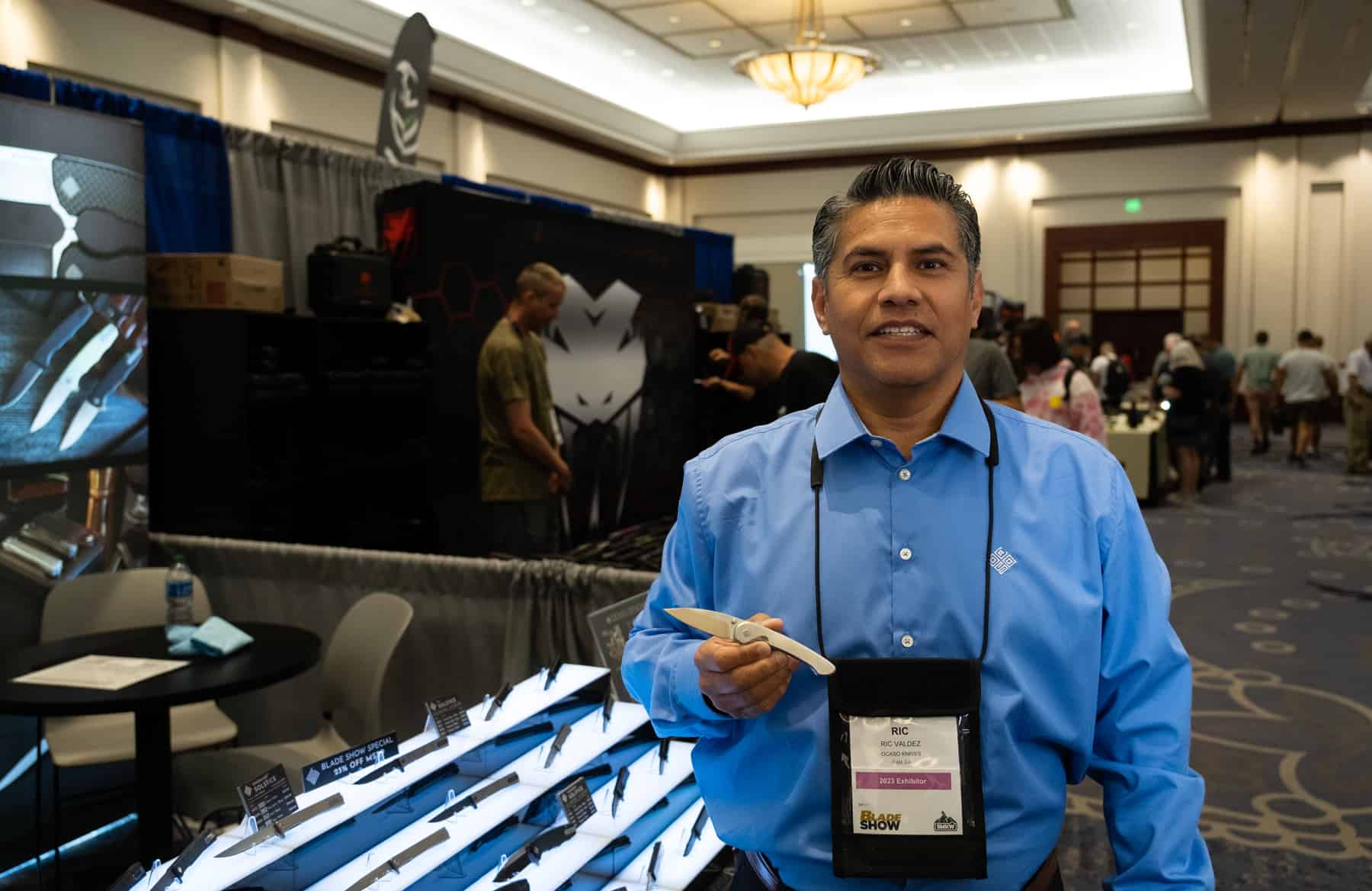 Ric Valdez of Ocaso Knives showing of a new model at Blade Show 2023.