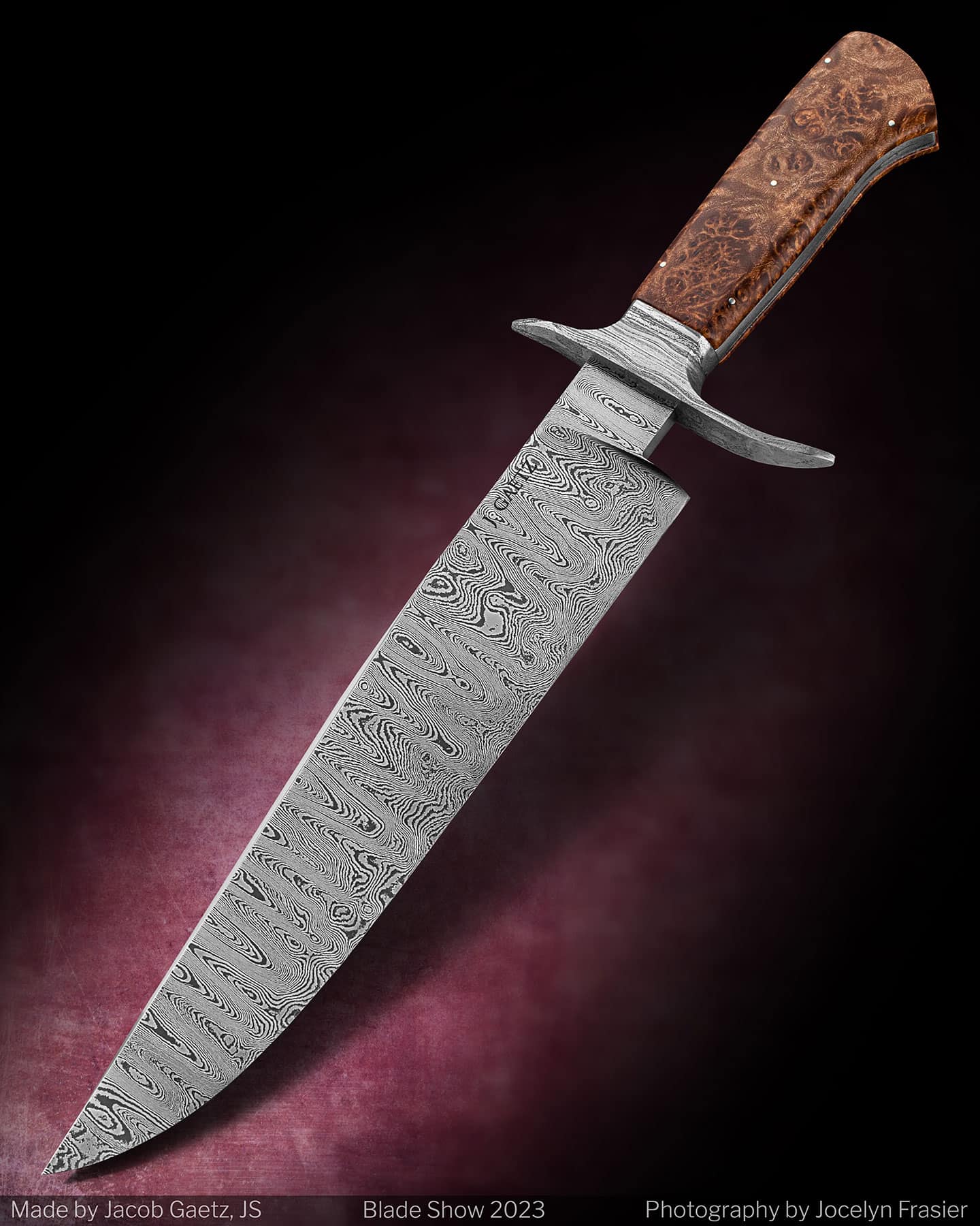 This custom Bowie knife features a maple burl handle and a ladder Damascus steel blade. 
