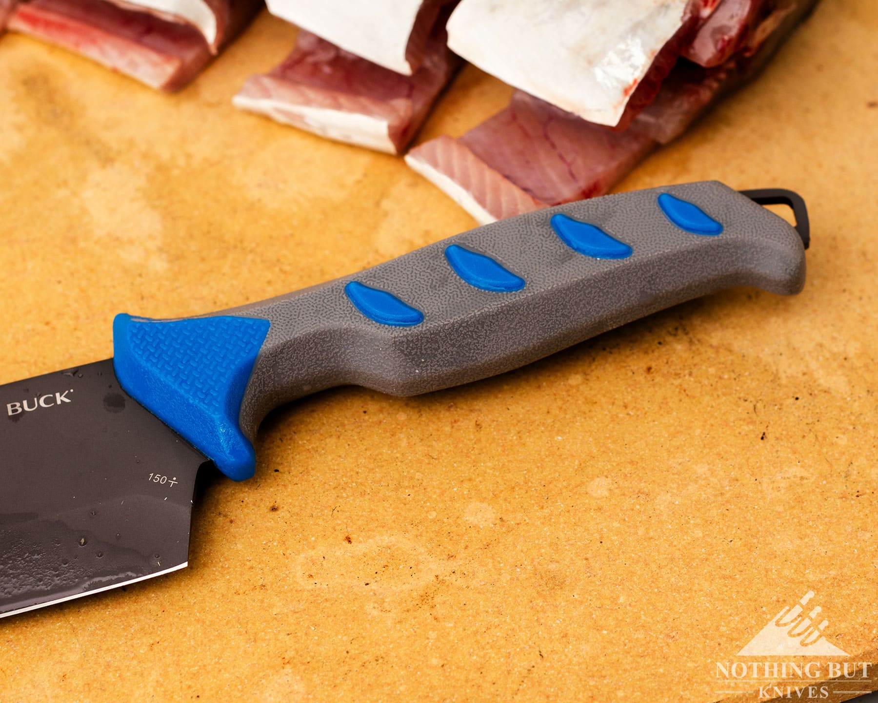 Buck Hookset cleaver on cutting surface with filleted fish in background.