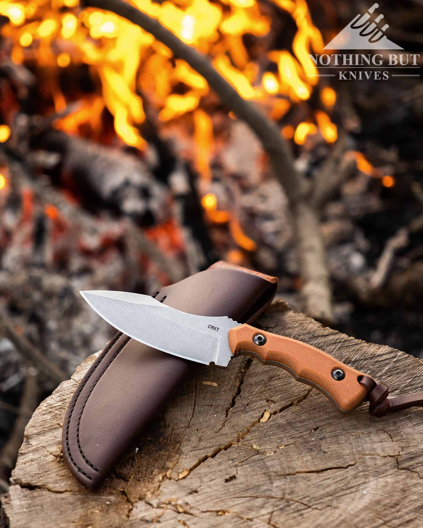 Crkt Bugsy Review - Image 1 The CRKT Bugsy resting on its leather sheath by a campfire.