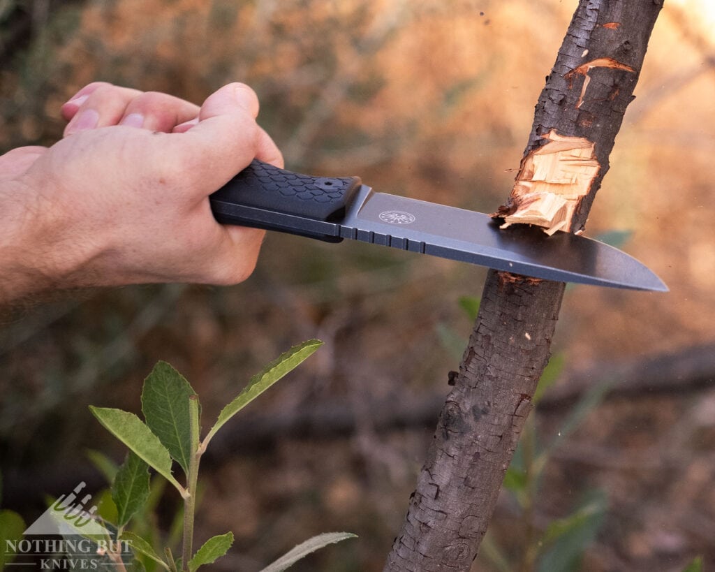 A slightly elevated view of the Off-Grid Tracker-X3 chopping a tree branch in a field.