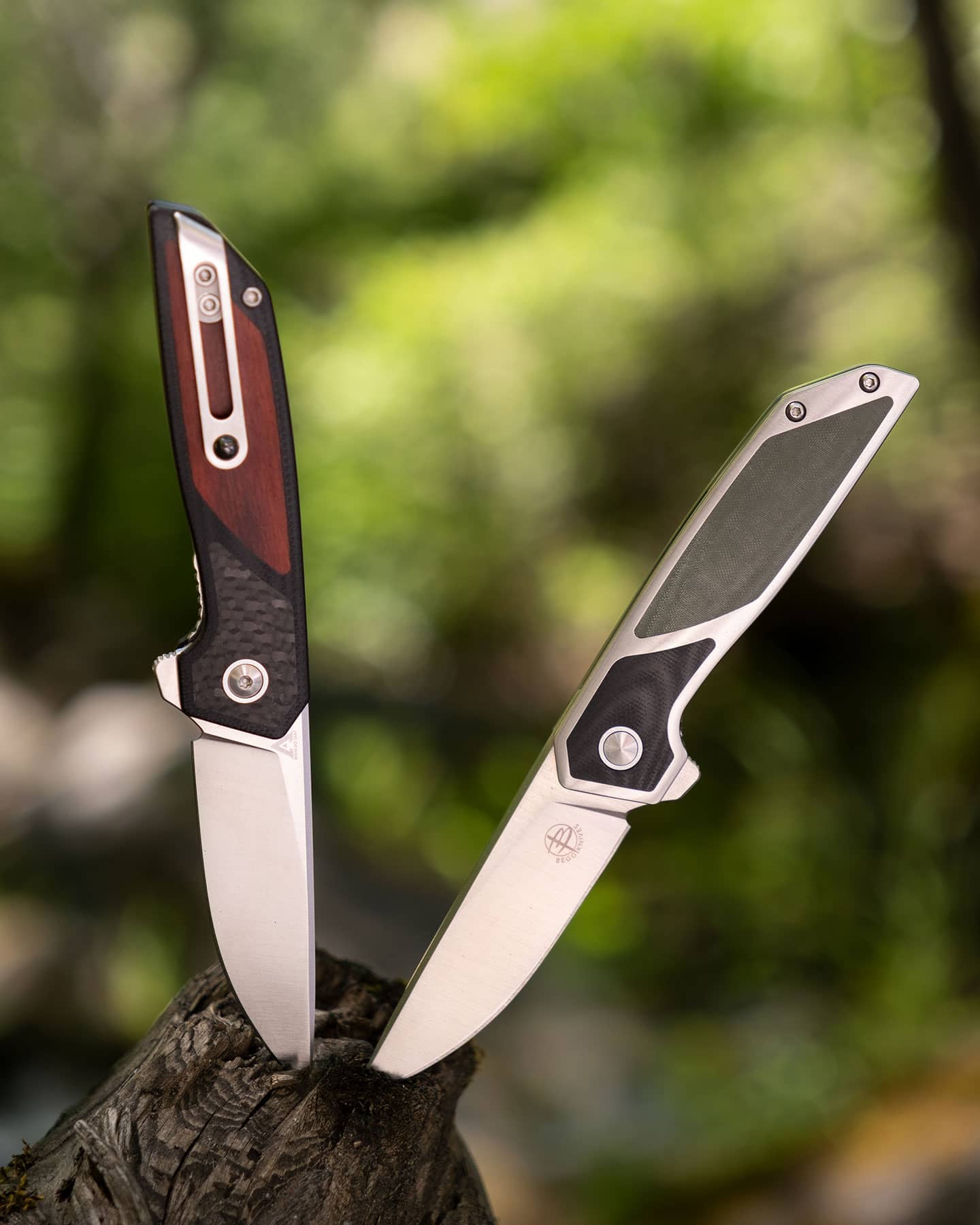 The two versions of the Begg Diamici pocket knife sticking out of a log in the forest.