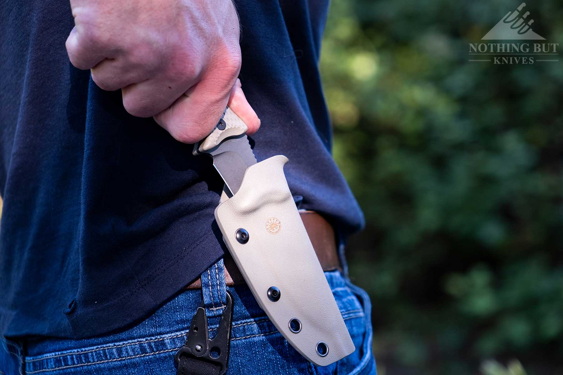 Off-Grid Sidekick Review - Image 8 A close-up of the Off-Grid Sidekick being deployed from its kydex sheath on a person's waist.