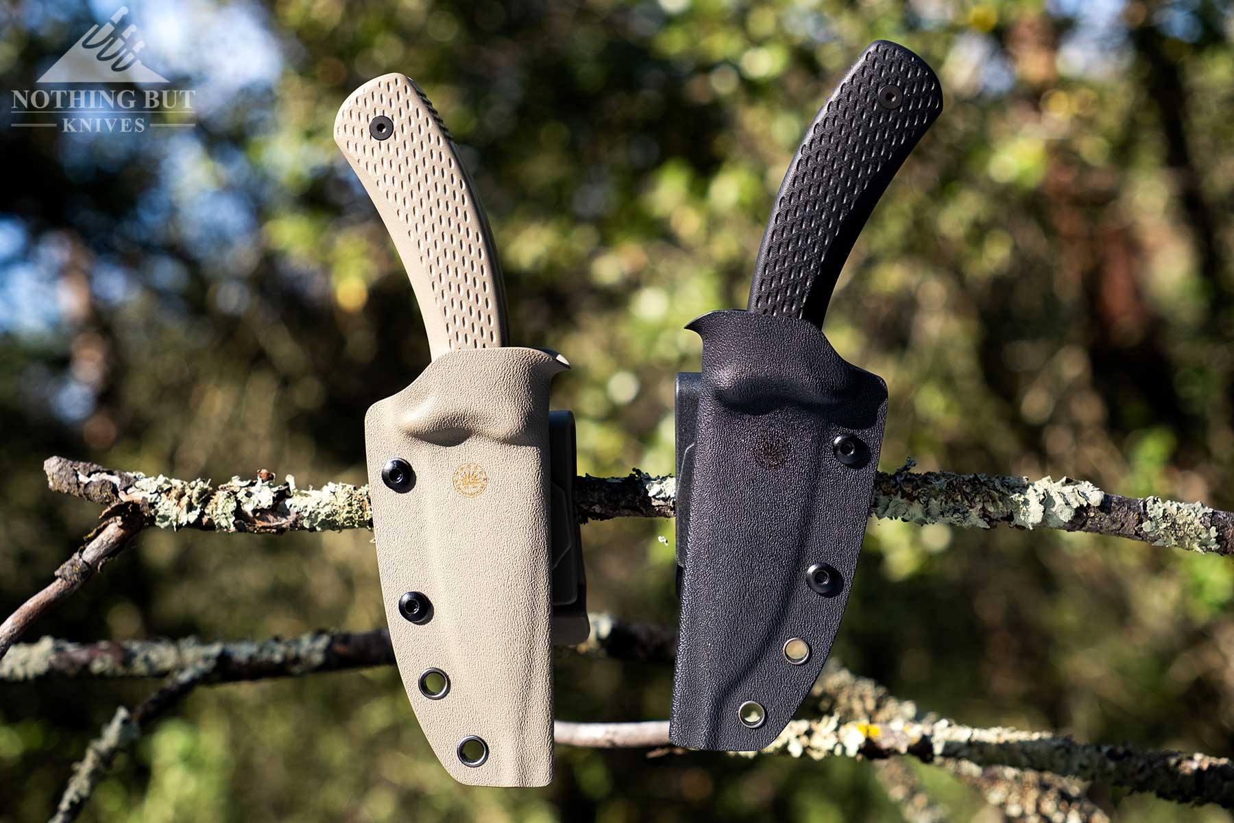 Off-Grid Sidekick Review - Image 6 The two versions of the Off-Grid Sidekick in their sheaths attached to a tree branch.