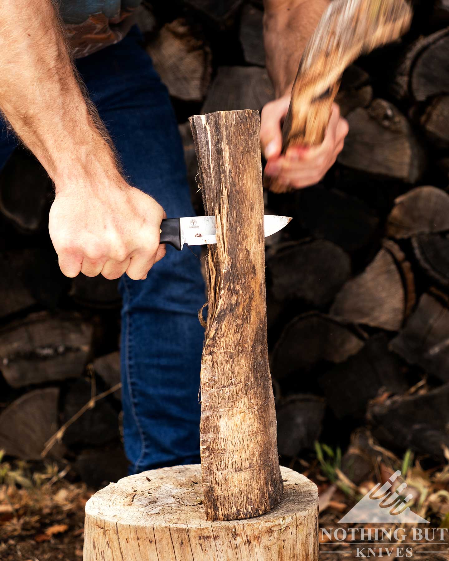 Boker Dbk Bushfriend 2000 Review - Image 10 The Boker Dutch Bushcraft Knives Bushfriend 2000 being used to baton through a piece of oak in front of a pile of firewood.