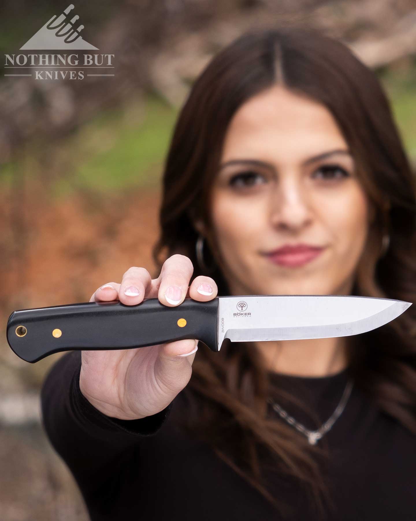 Boker Dbk Bushfriend 2000 Review - Image 5 A young woman holding up the Scandi grind version of the Boker DBK Bushfriend 2000.