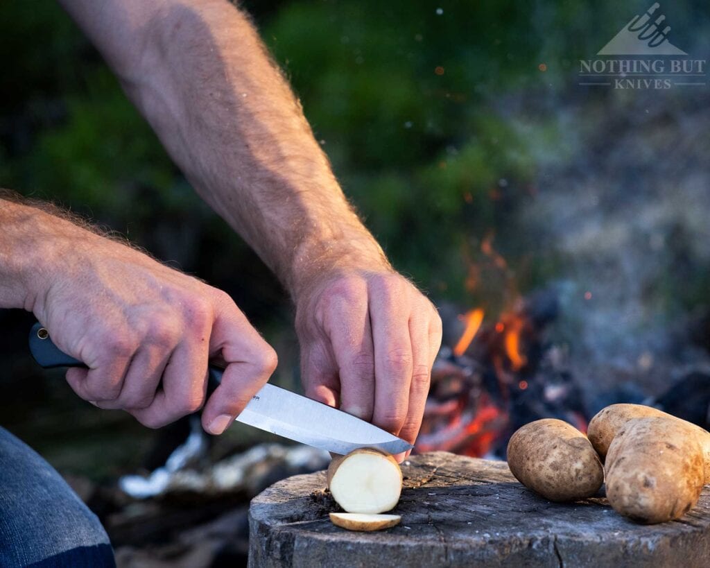 Boker Dbk Bushfriend 2000 Review - Image 19 The Bushfriend 2000 fixed blade knife being used to slice potatoes for dinner next to a campfire. in the forest of the Sierra Nevada Mountains.