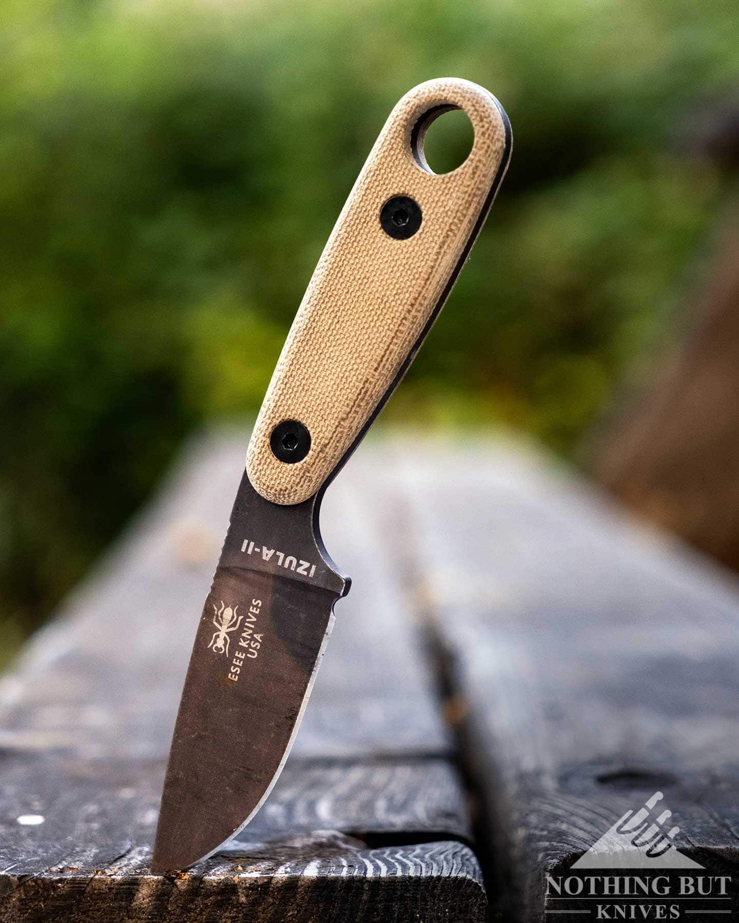 Our Favorite Fixed Blade Edc Knives And How To Carry Them - Image 20 The Esee Izula 2 compact survival knife shown here outdoors on a wooden picnic table bench.