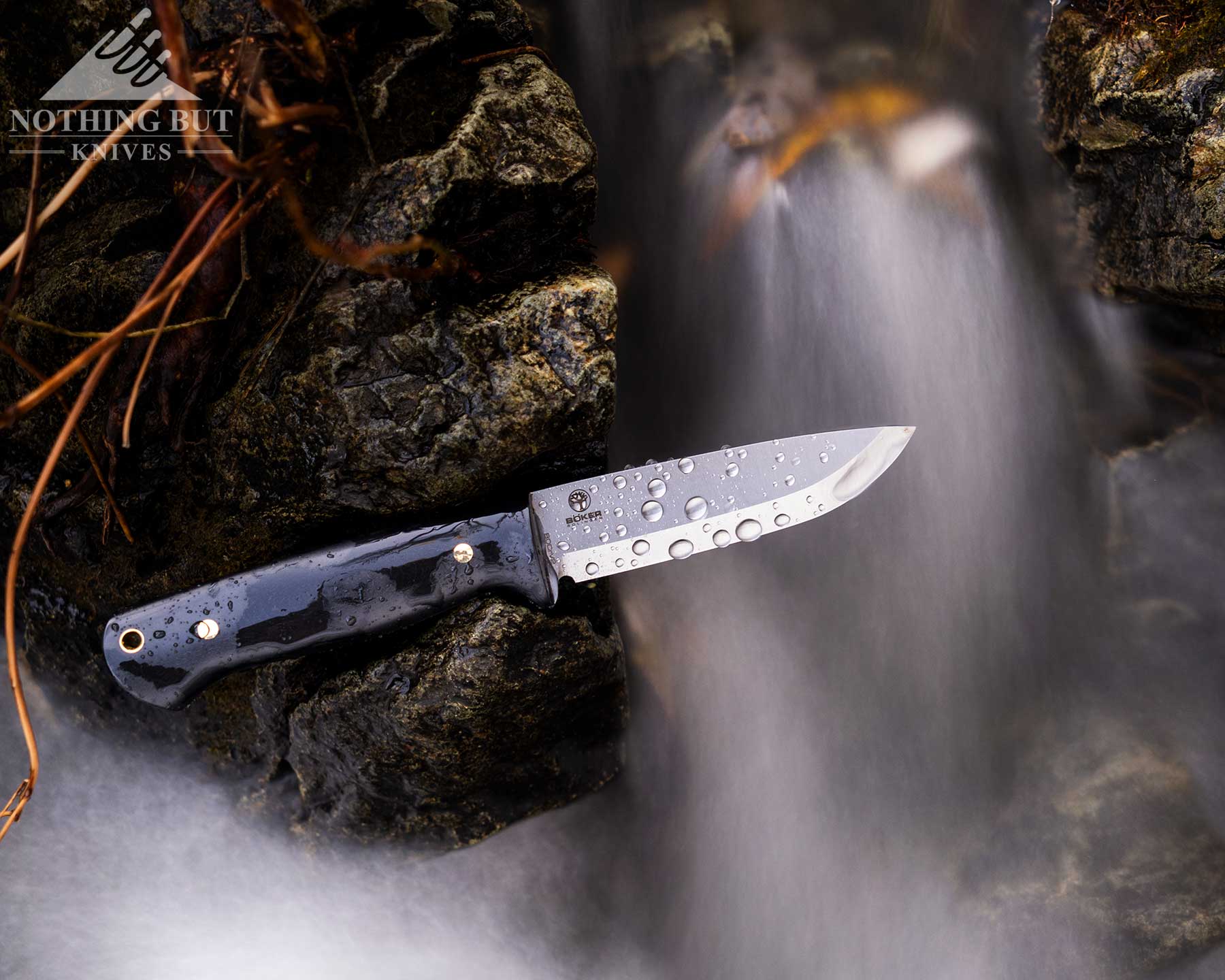 Boker Dbk Bushfriend 2000 Review - Image 4 An overhead view of the Boker DBK Bushfriend 2000 covered in water droplets from a creek it is set next to.