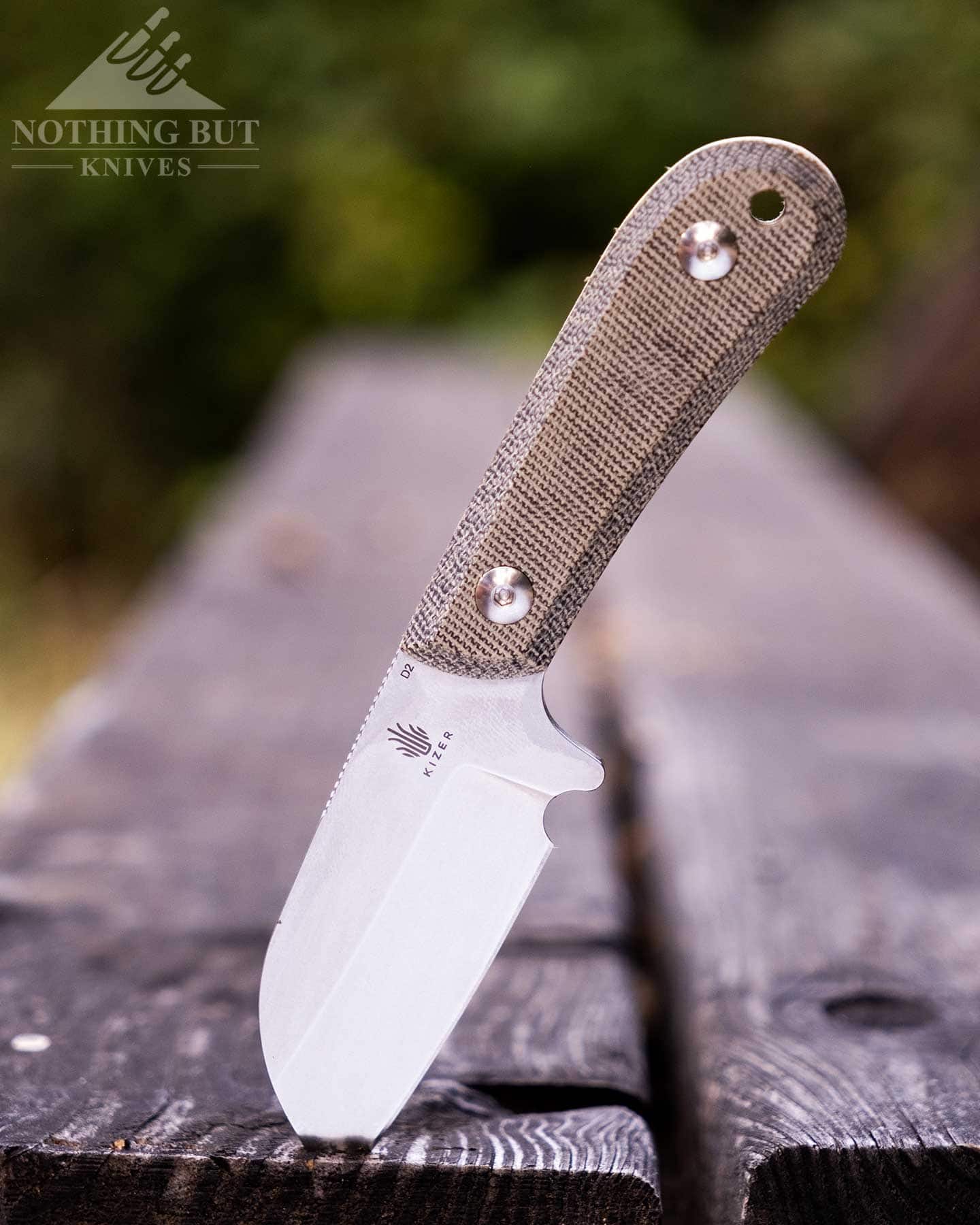 Our Favorite Fixed Blade Edc Knives And How To Carry Them - Image 18 The Kizer Deckhand with a sheepsfoot blade on a picnic table bench outdoors.