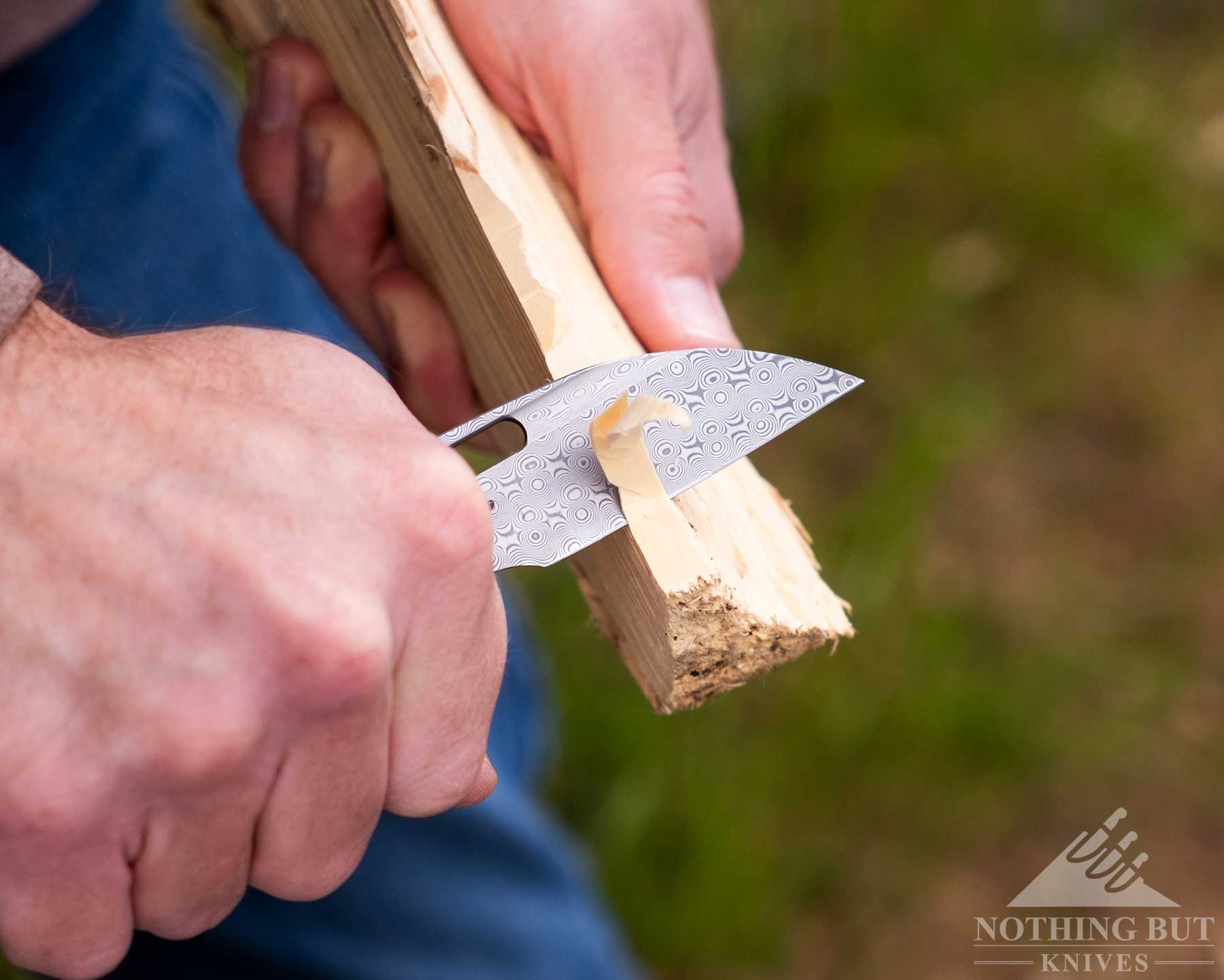 Kansept Vivid Review - Image 6 A close-up of the Kansept Vivid pocketknife being used to carve a stick.