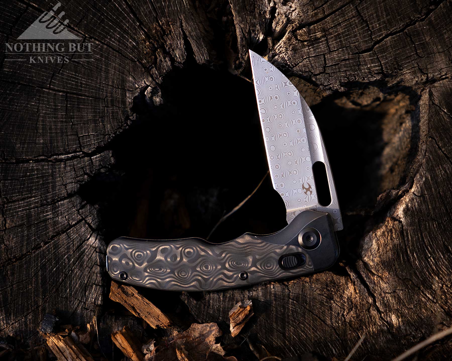 Kansept Vivid Review - Image 7 The Kansept Vivid shown here with its blade in the half open position in the inside of a hollowed out log.