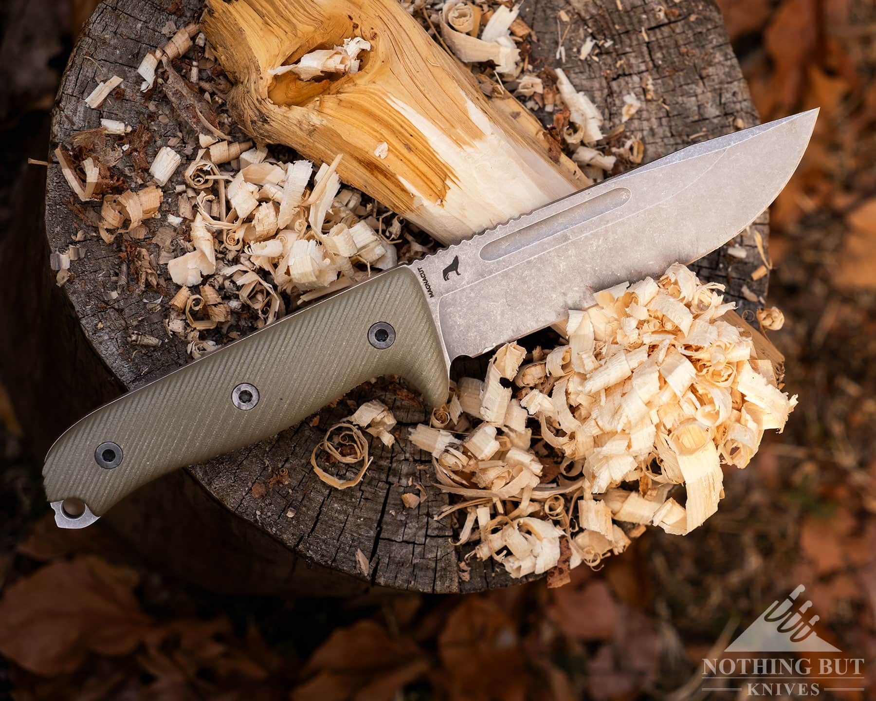 An overhead view of the Reiff Vicon survival knife on top of a feather stick it was used to make. 