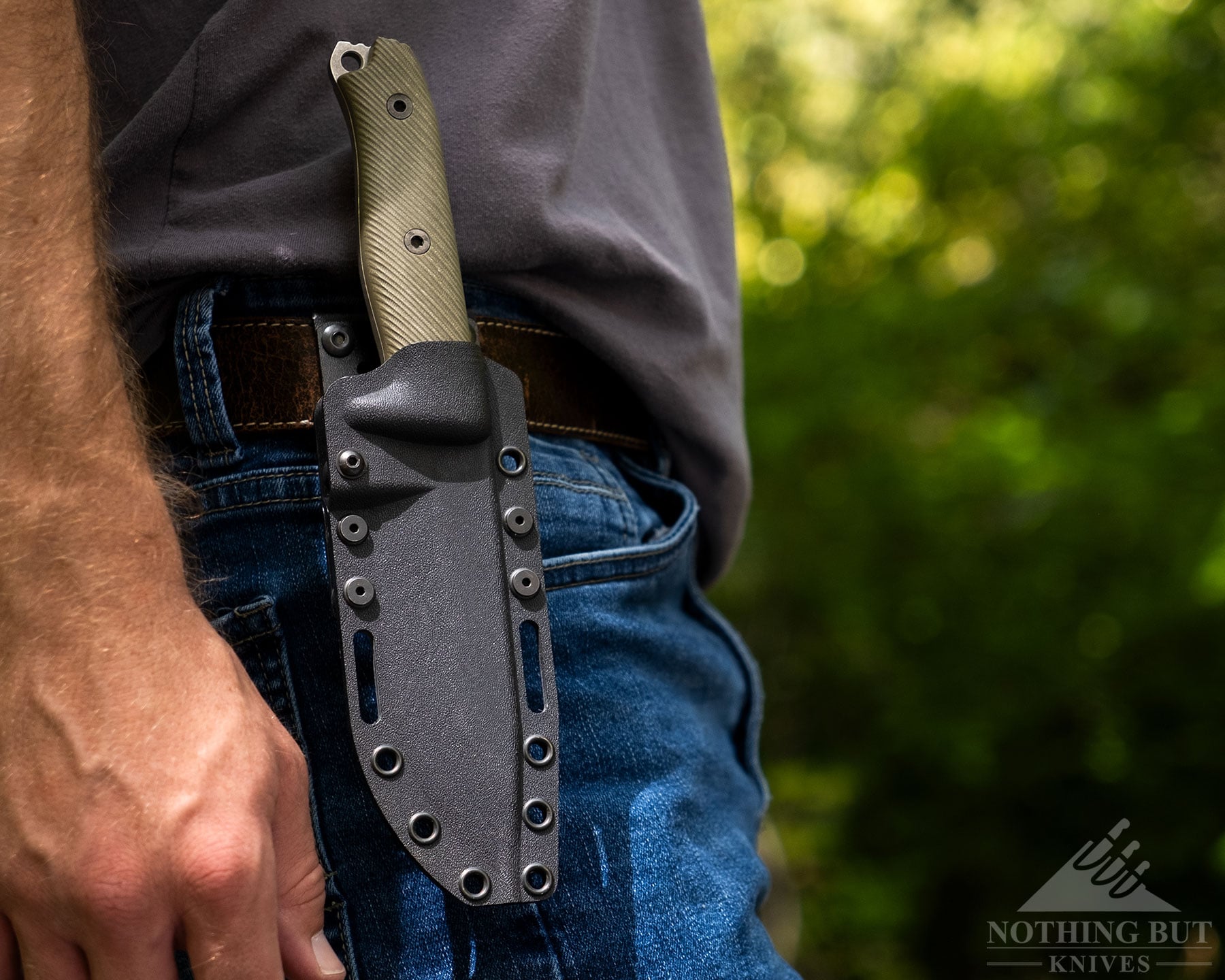 A close-up of the Reiff Vicon knife in its kydex sheath on the right side of a person's hip.