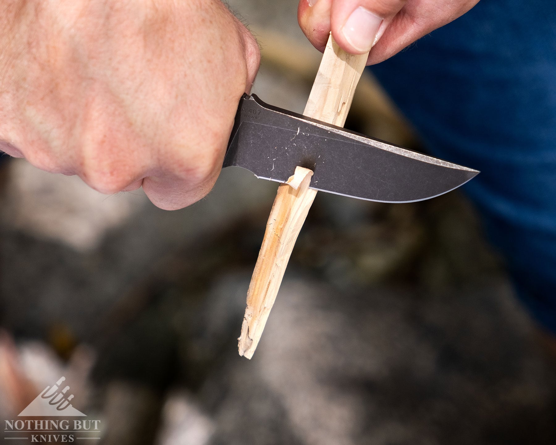Toor Knives Brauler Review - Image 3 An overhead view of the Toor Brauler being used to carve a stick outdoors.