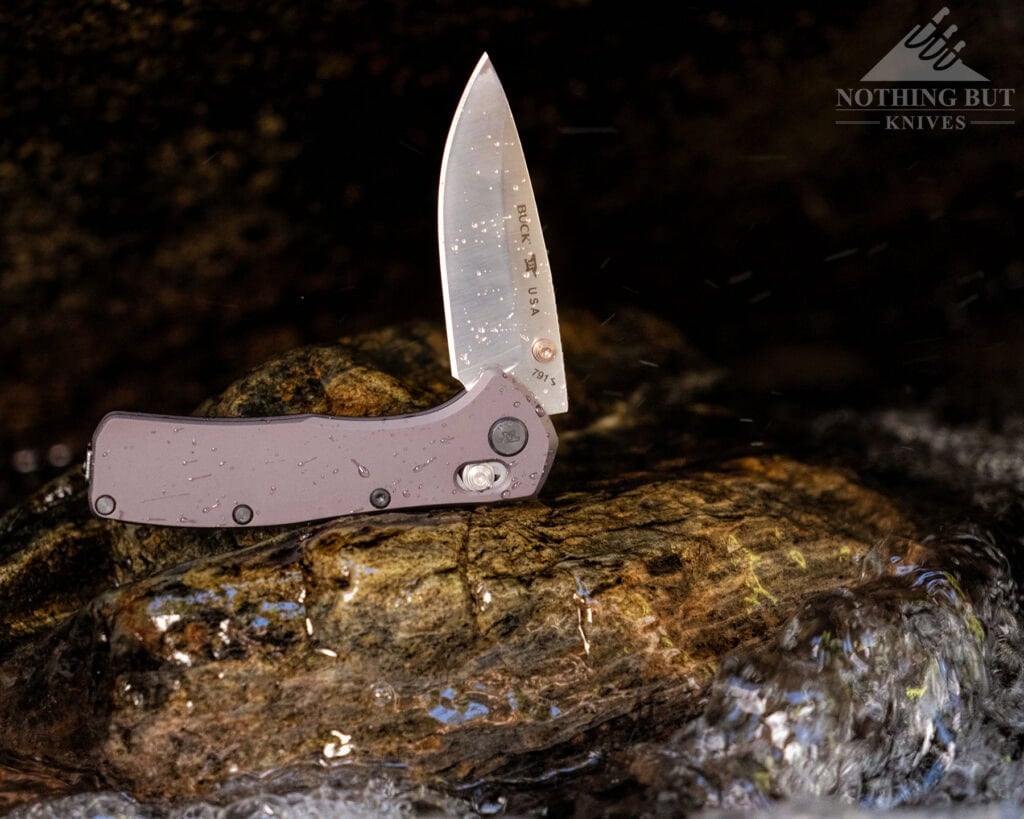 The Buck Range Elite pocket Knife with the blade in the half open position in a mountain creek. 