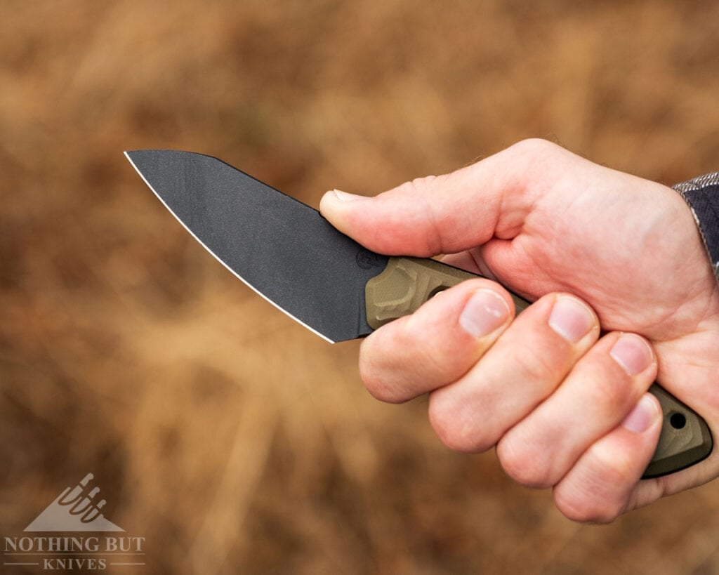 Schwarz Knives Overland X Review - Image 5 A close-up of a person's right hand gripping the G10 handle of the Overland X fixed blade knife.