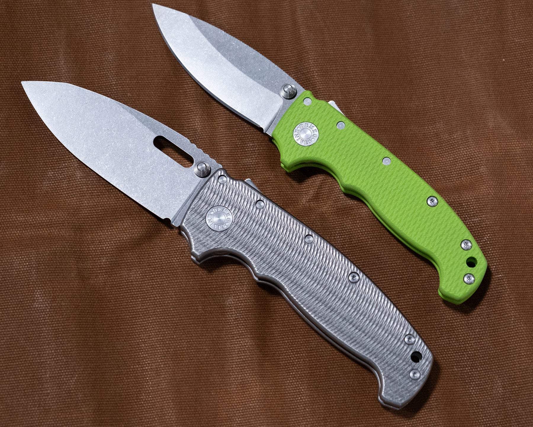 An elevated view showing two different size options of the Demko Knives AD20 folding knife. 