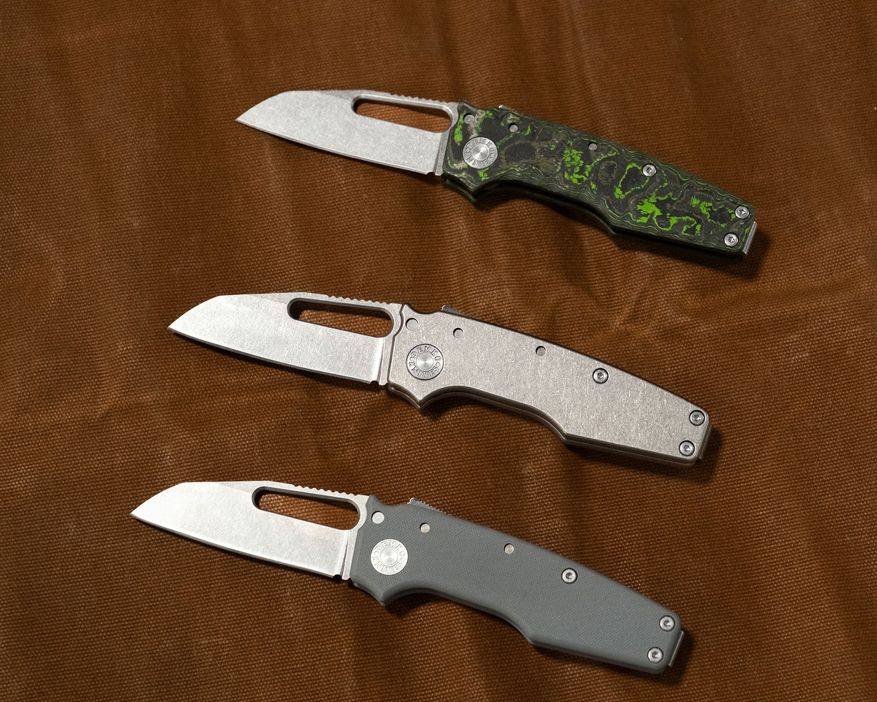 An overhead view of three variations of the Demko Shark Cub folding knife handle.
