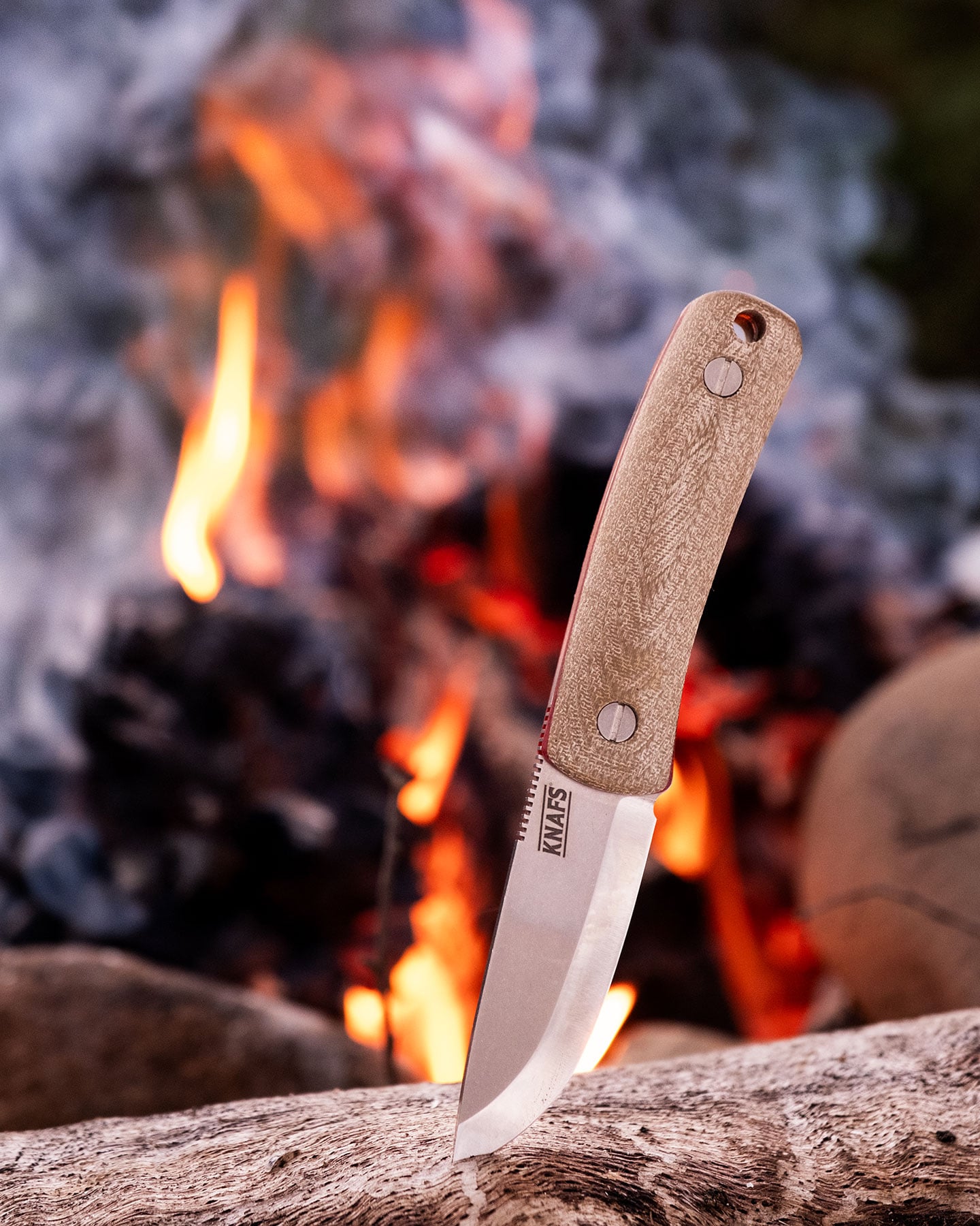 Blades N' Tales: Looking Inside The Knafs Rocket Ship - Image 6 The Knafs Lulu fixed blade knife shown here sticking in a log in front of a campfire.