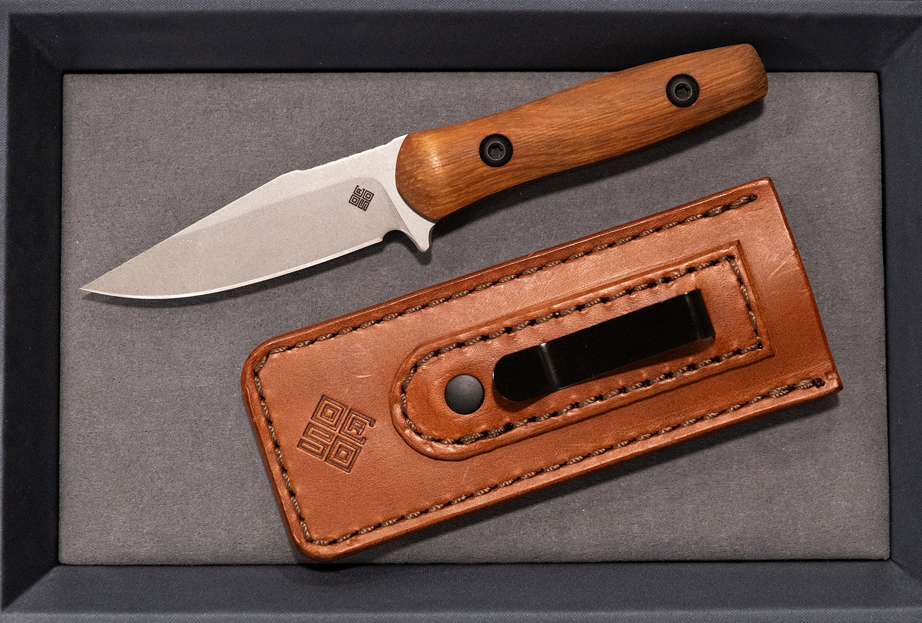 An overhead view of the Ocaso Regis fixed blade knife shown here with its brown, leather pocket sheath. 