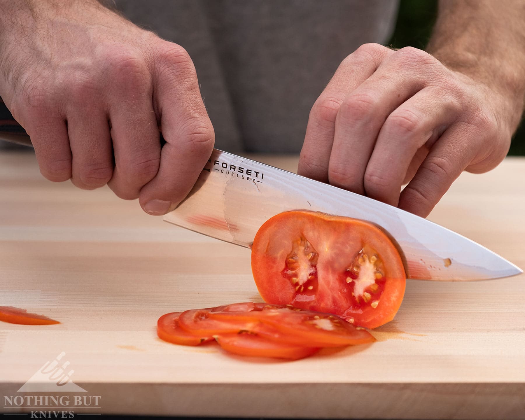 Hexclad Chef Knife Review - Is It Just Marketing Hype? - Image 7 A close-up of the Forseti Cutlery Chef knife being used to slice a tomato.