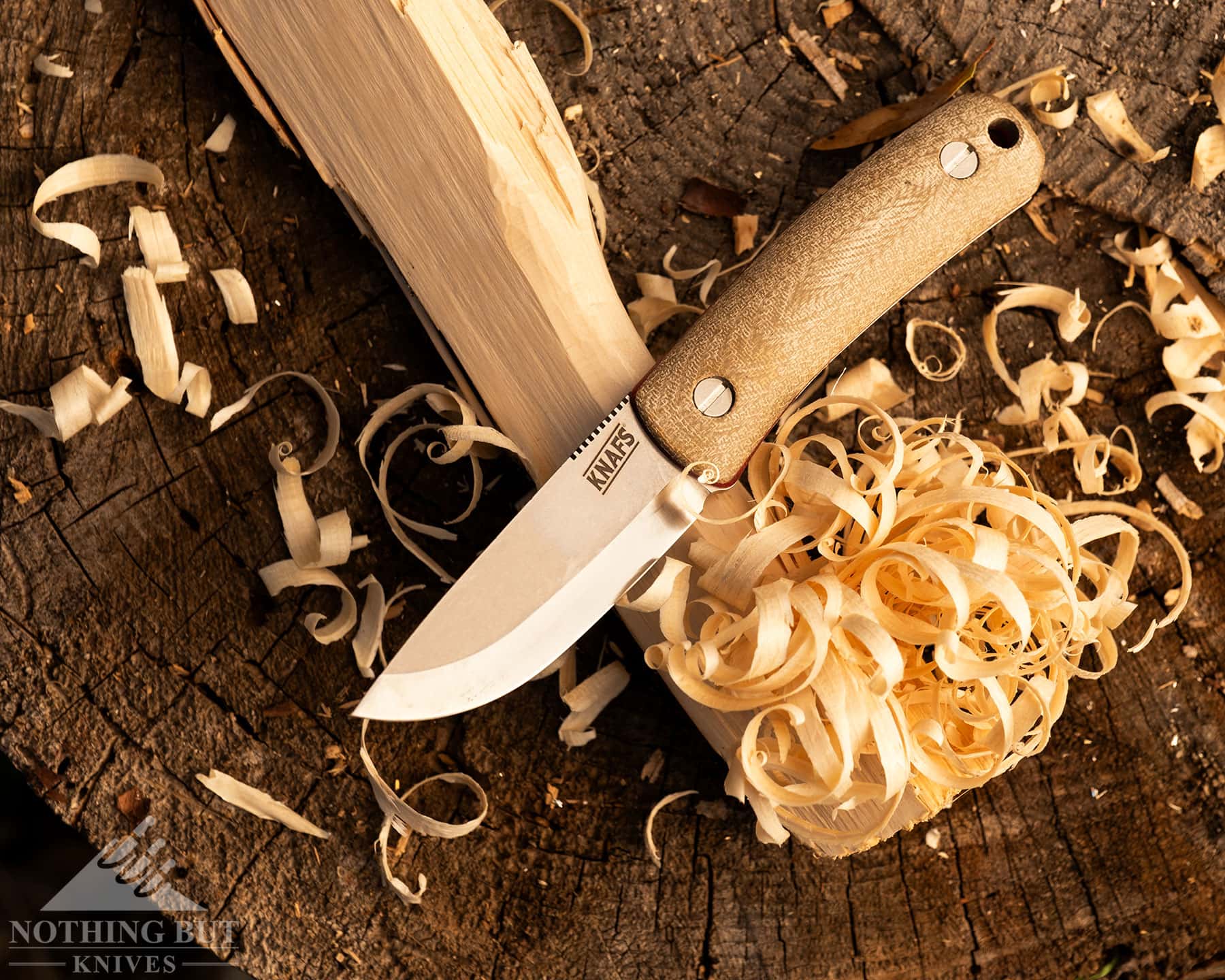Knafs Lulu Review - Image 11 Fixed blade bushcraft knife with a feather stick making kindling on a log.