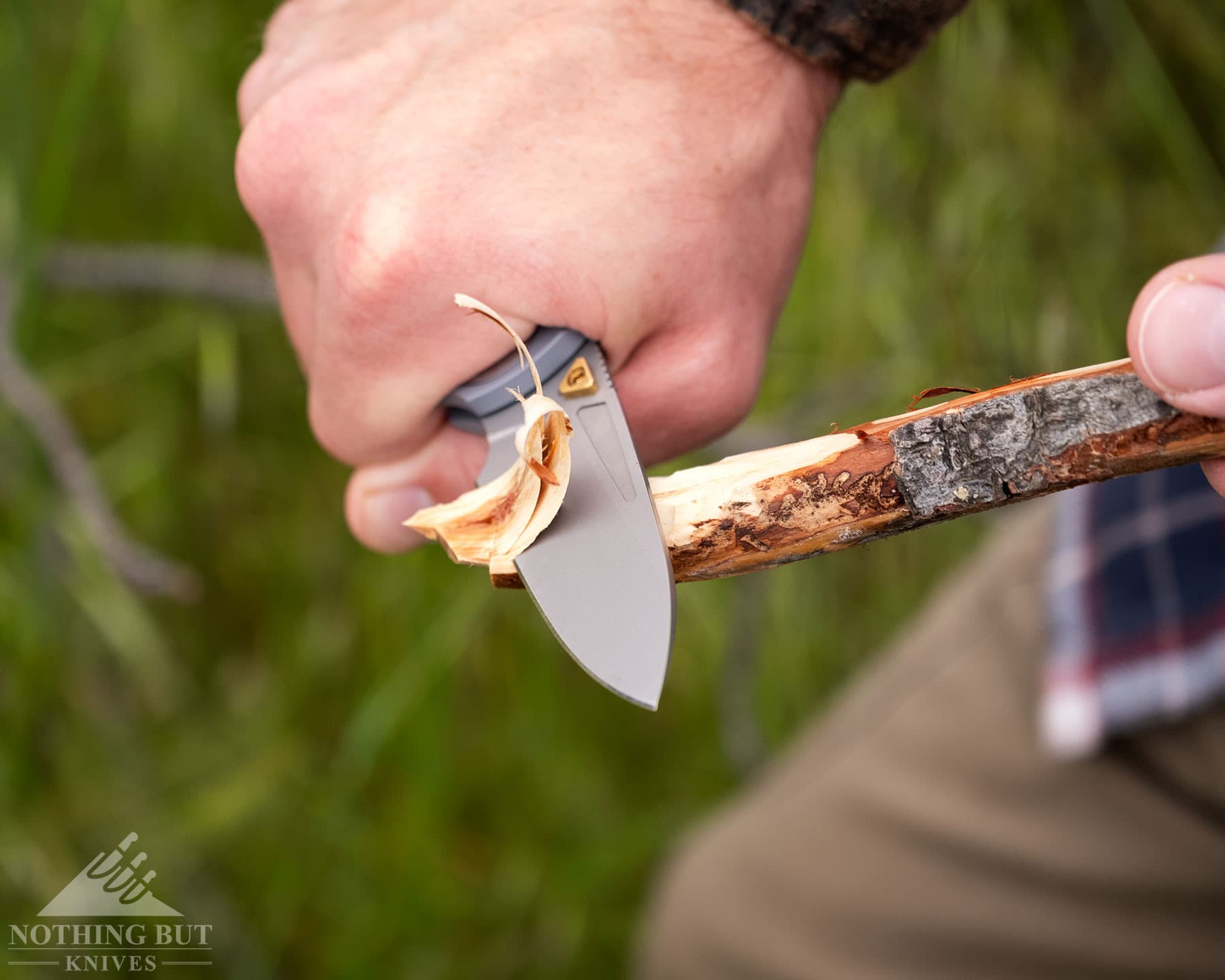 Worksharp Rmx Thumbstud Knife Review - Image 6 A slightly elevated photo of the Work Sharp RMX pocket knife being used to carve a stick.