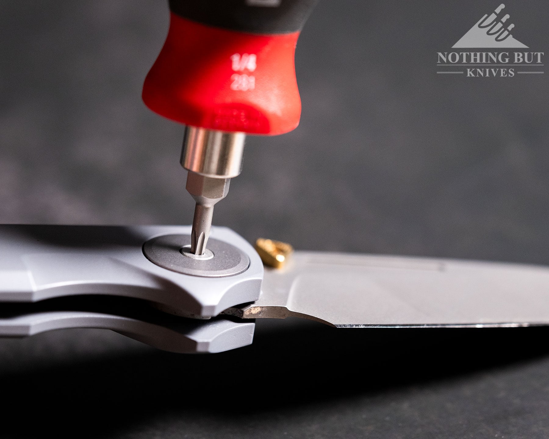 Worksharp Rmx Thumbstud Knife Review - Image 4 A side view of the Work Sharp RMX folding knife with a hex driver adjusting its pivot screw.