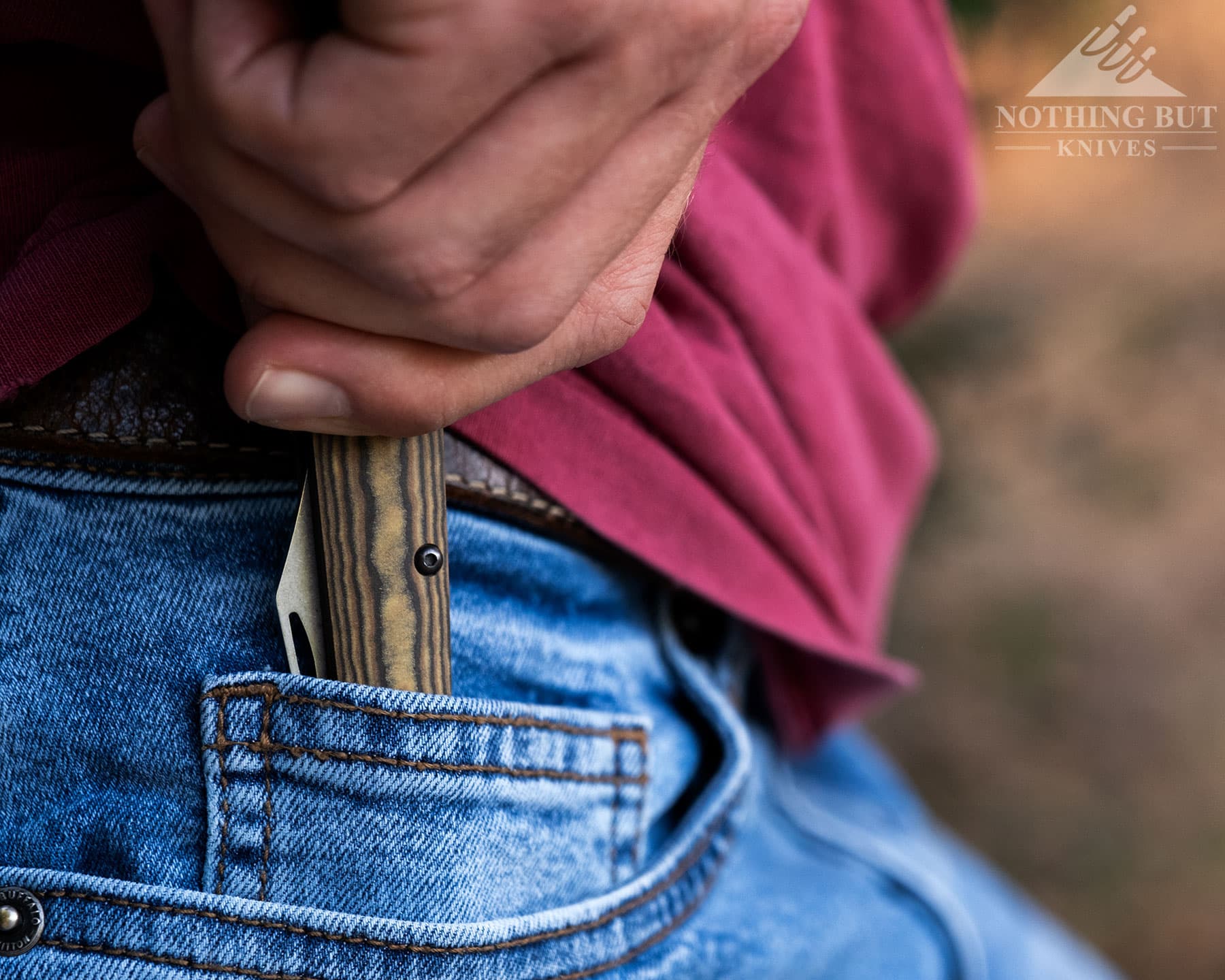 A close-up of the Case Crossroads Barlow folding knife being put into a person's right front jeans pocket.
