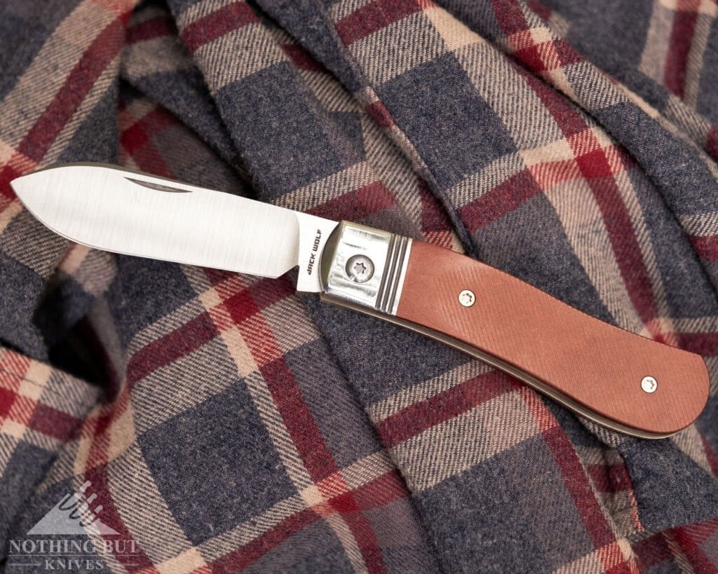 Jack Wolf Knives K9 Jack Review - Image 5 An overhead view of the Jack Wolf K9 knife with its blade in the open position on a flannel shirt.
